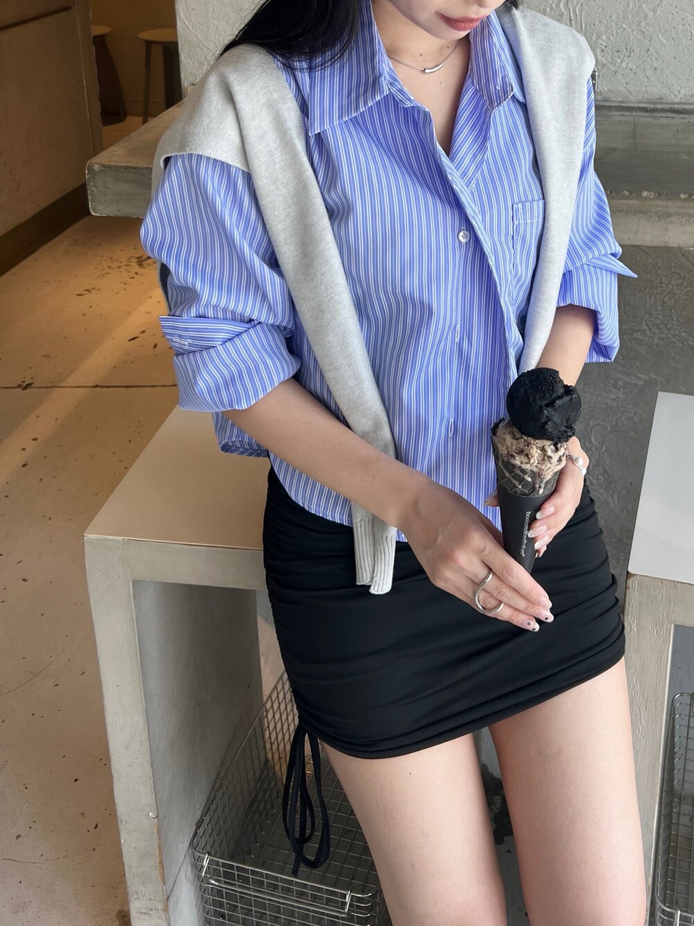 ブラック系のスニーカー、ブラック系のスカート、ブルー系のシャツ/ブラウスを着用したレディースの冬コーディネートの2枚目の写真