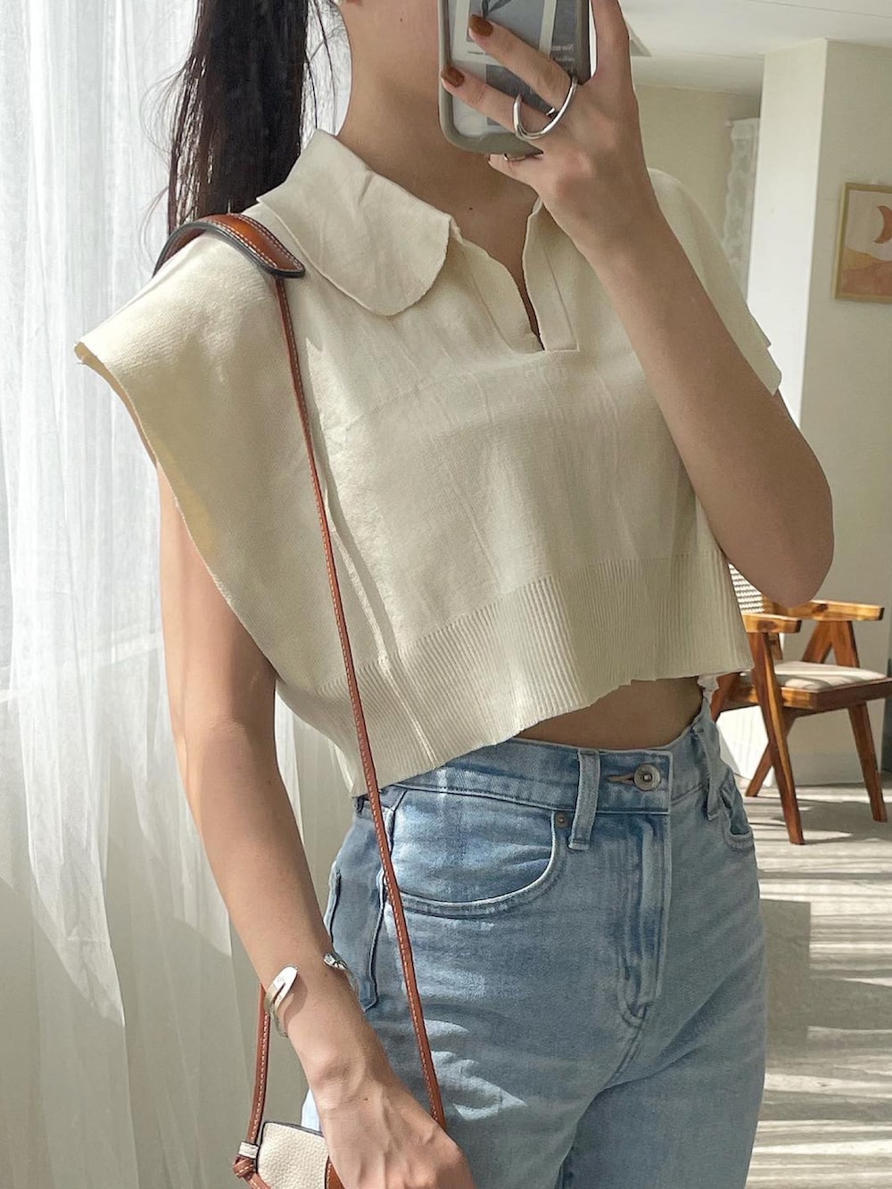 ベージュ系のニット/セーター、ブルー系のデニムパンツ、レッド系のパンプスを着用したレディースの夏コーディネートの2枚目の写真