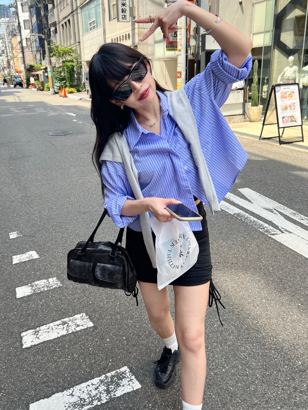 ブラック系のスニーカー、ブラック系のスカート、ブルー系のシャツ/ブラウスを着用したレディースの冬コーディネートの3枚目の写真