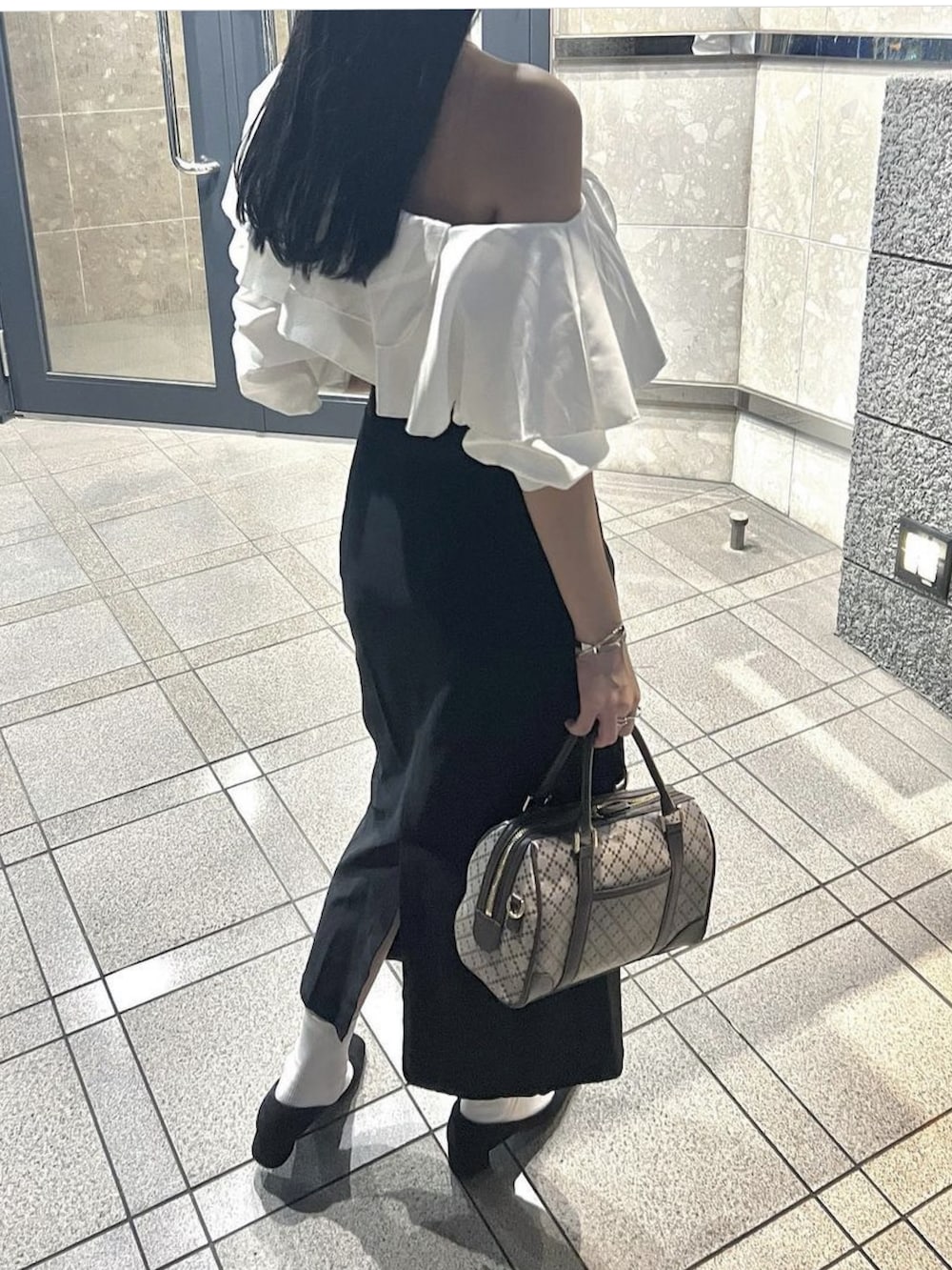 ホワイト系のシャツ/ブラウス、ブラック系のスカート、ブラック系のパンプスを着用したレディースの秋コーディネートの2枚目の写真