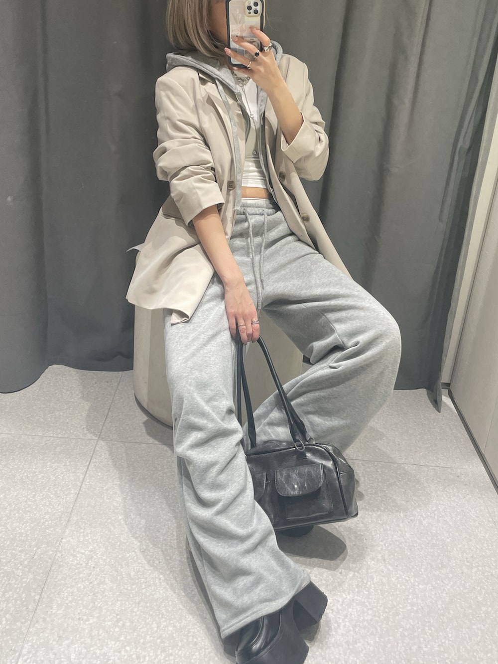 ベージュ系のテーラードジャケット、ホワイト系のタンクトップ、グレー系のパーカーを着用したレディースの夏コーディネートの2枚目の写真