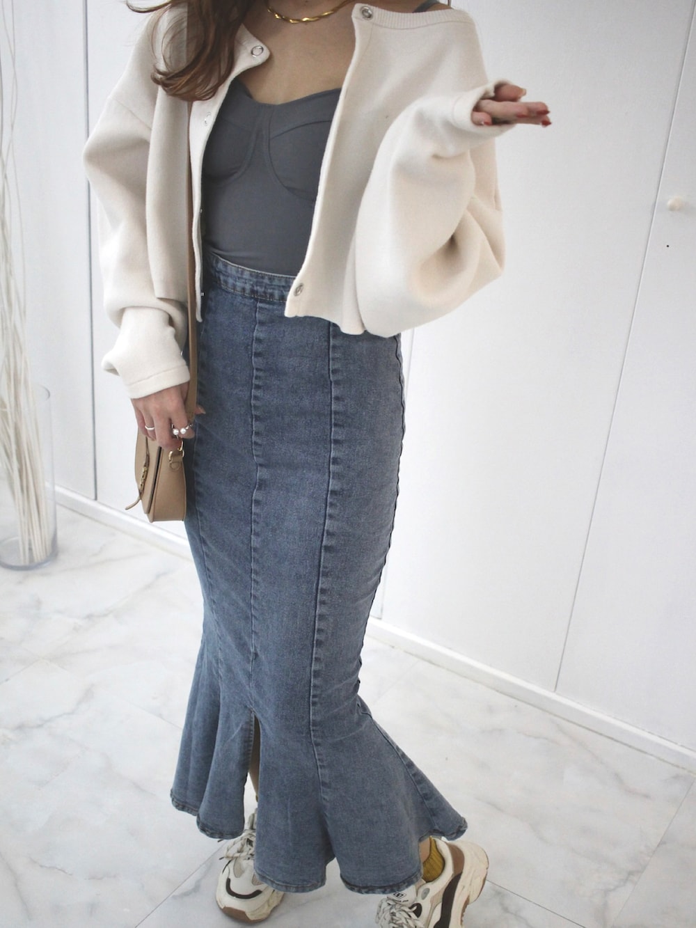 ホワイト系のカーディガン/ボレロ、ベージュ系のスニーカー、ブルー系のキャミソールを着用したレディースの春コーディネートの2枚目の写真