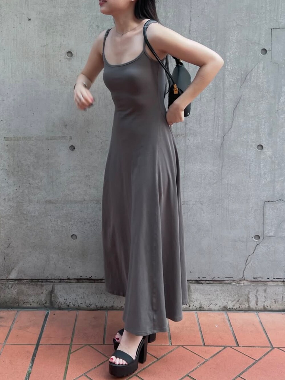 ブラック系のテーラードジャケット、グレー系のワンピース、ブラック系のハンドバッグを着用したレディースの秋コーディネートの3枚目の写真