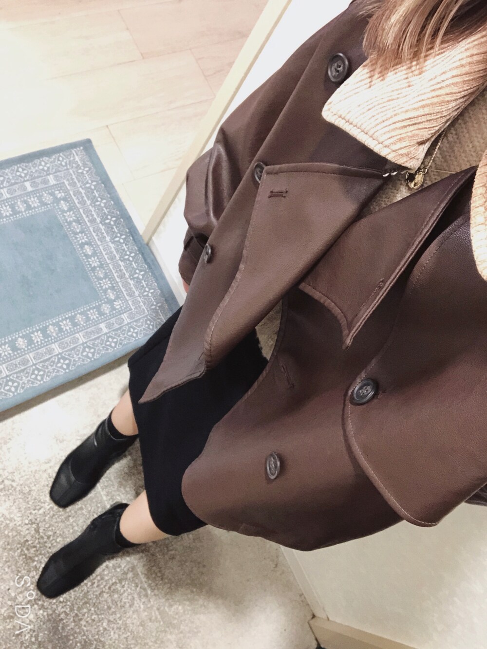 ブラック系のブーツ、ブラック系のスカート、ベージュ系のニット/セーターを着用したレディースの春コーディネートの2枚目の写真