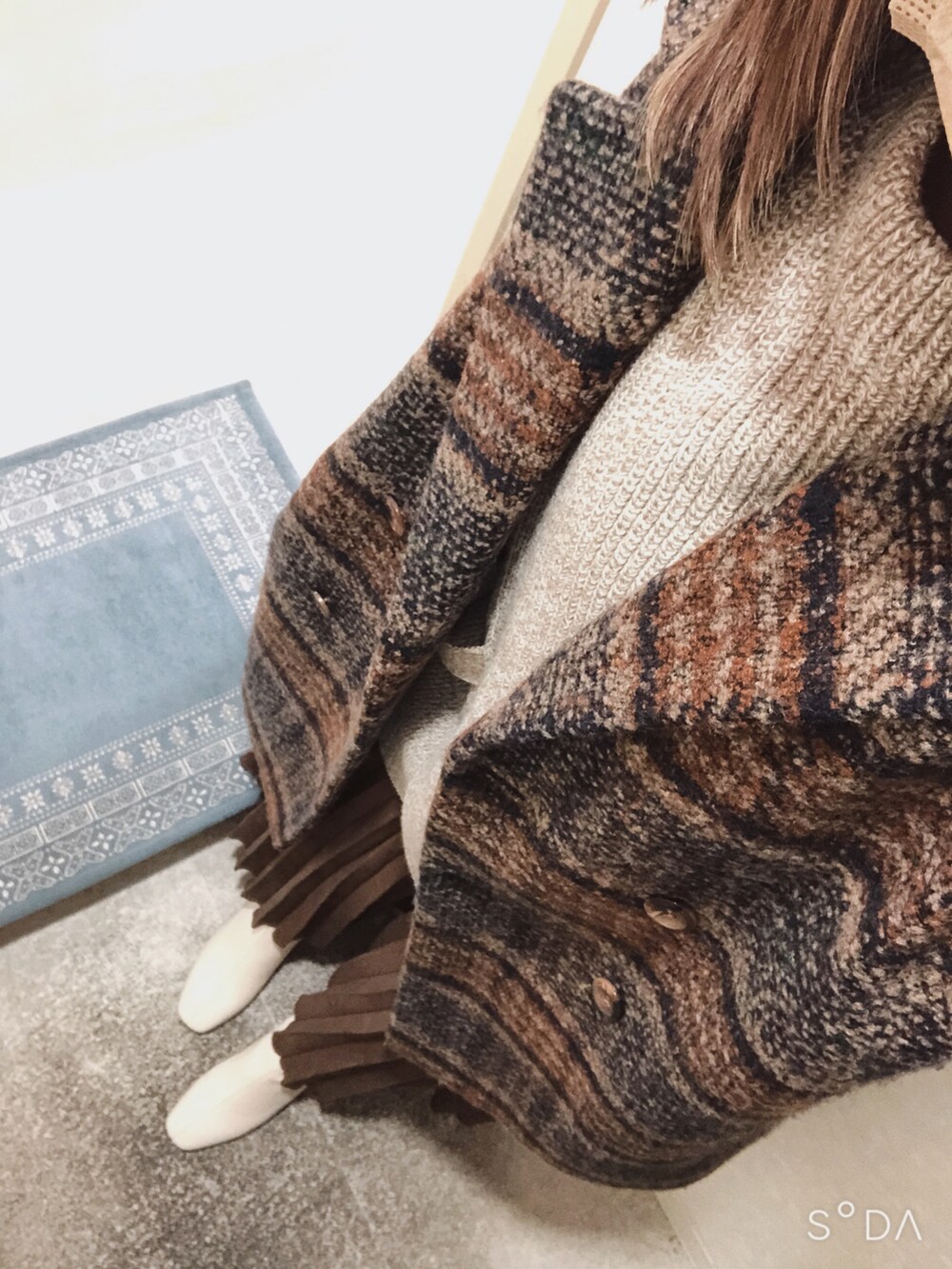 ブラウン系のスカート、ホワイト系のブーツ、ブラウン系のその他アウターを着用したレディースの冬コーディネートの2枚目の写真