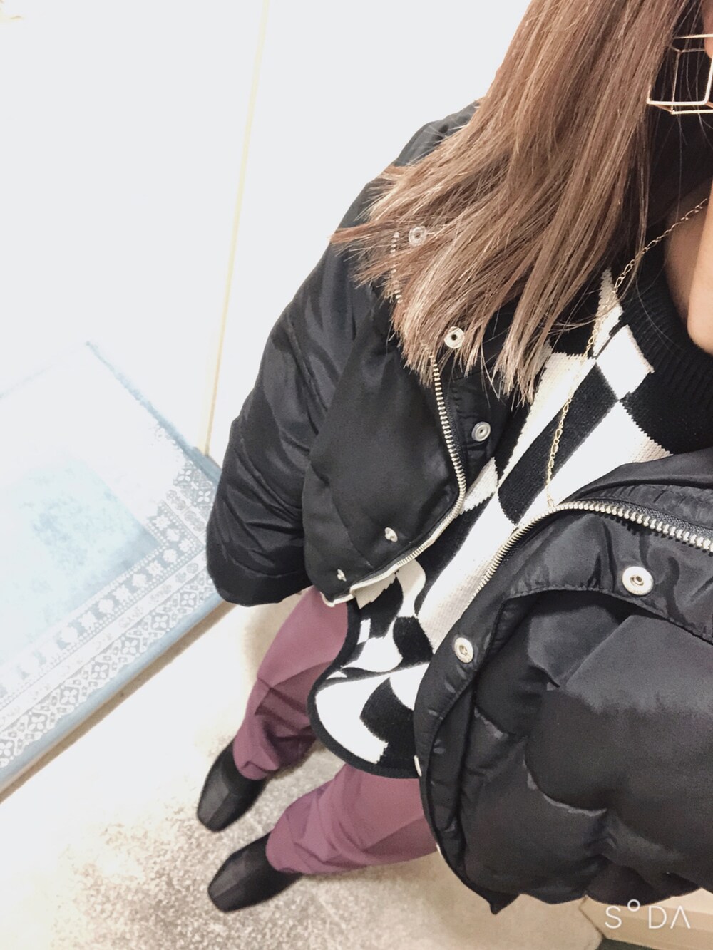 ブラック系のニット/セーター、ブラック系のブーツ、ブラック系のダウンジャケット/コートを着用したレディースの冬コーディネートの2枚目の写真