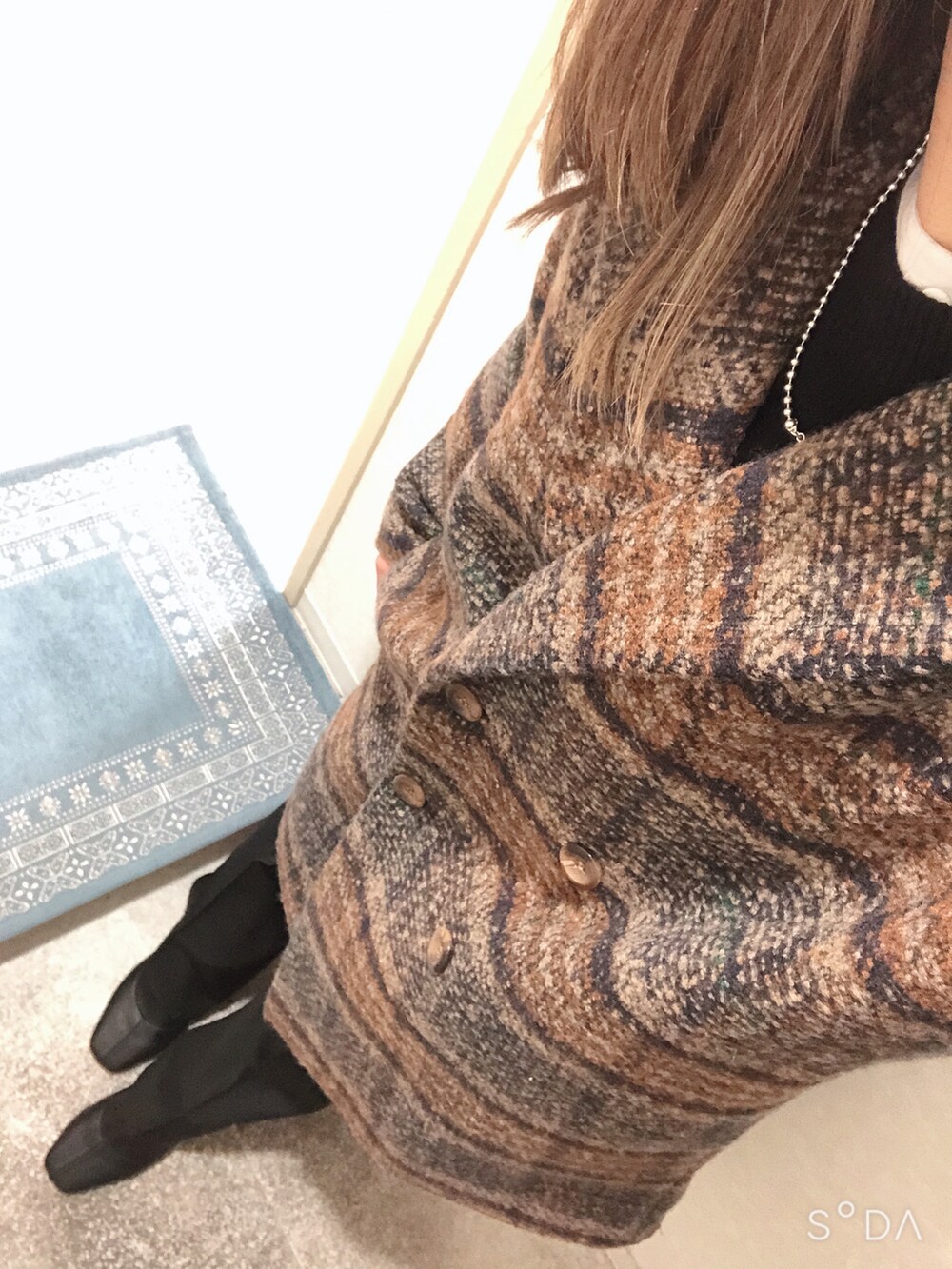 ブラック系のニット/セーター、ホワイト系のシャツ/ブラウス、ブラック系のその他パンツを着用したレディースの冬コーディネートの2枚目の写真