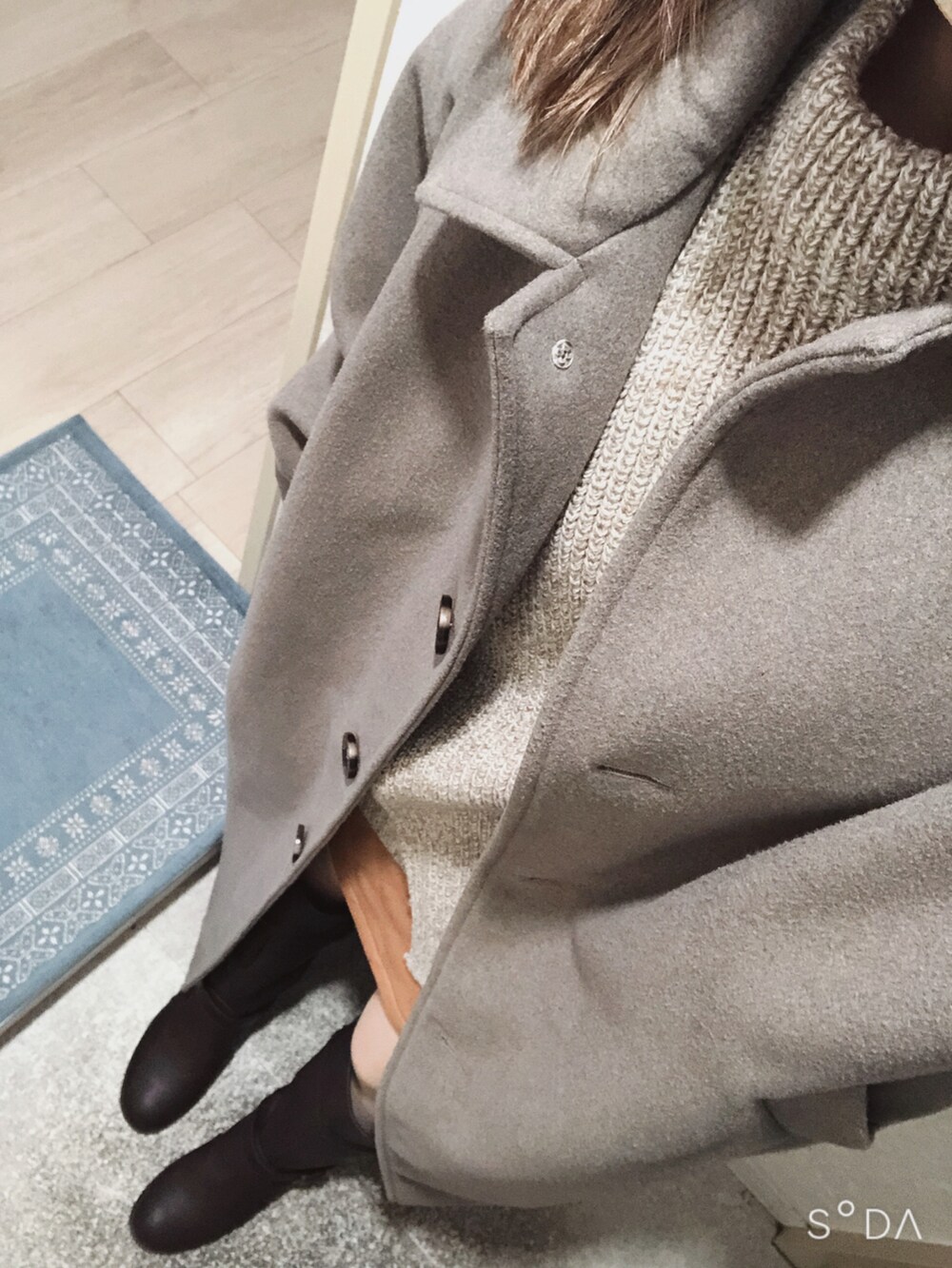 ブラウン系のニット/セーター、オレンジ系のスカート、ブラウン系のブーツを着用したレディースの冬コーディネートの2枚目の写真