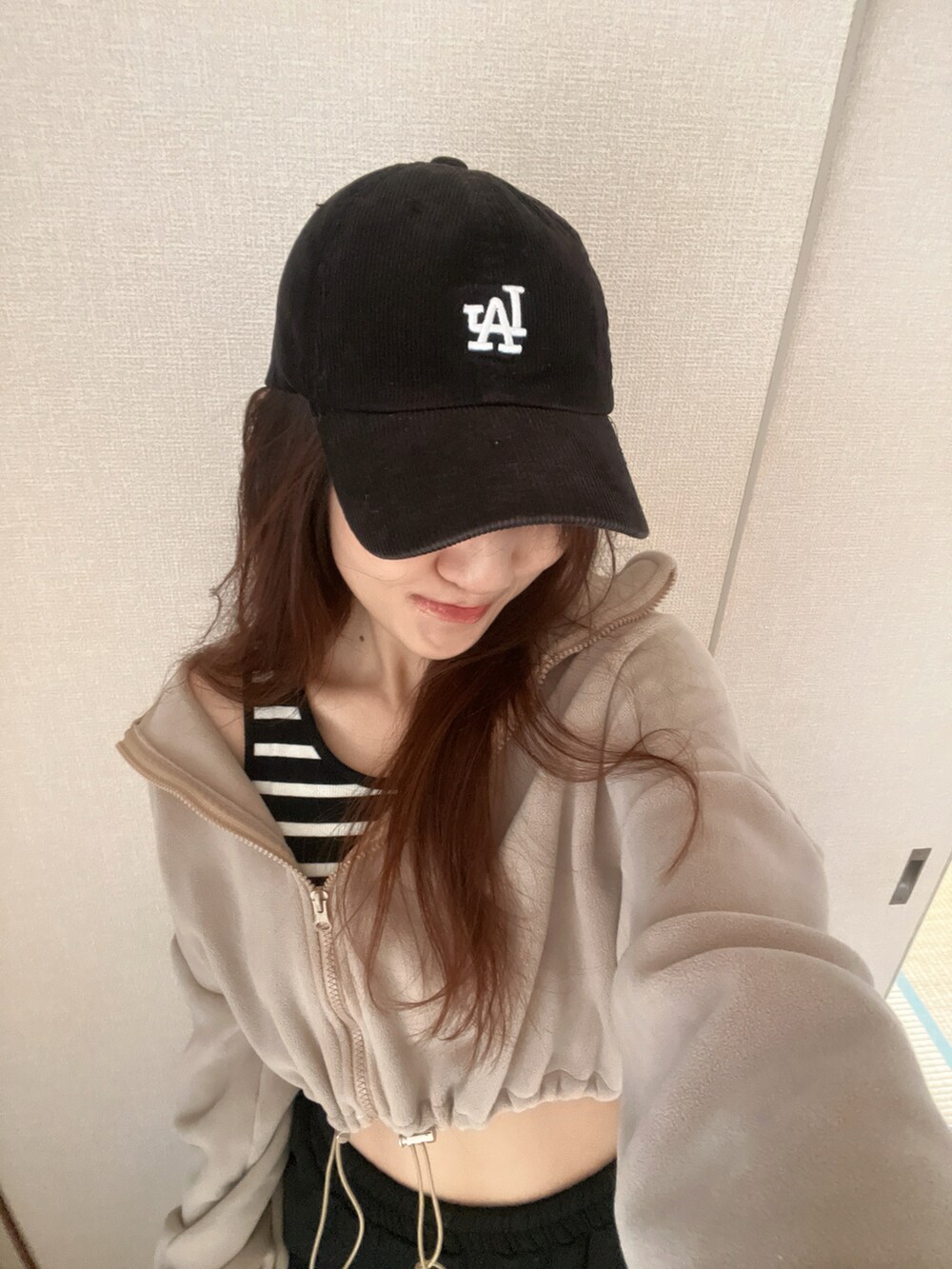 ブラック系のキャップを着用したレディースの秋コーディネートの2枚目の写真
