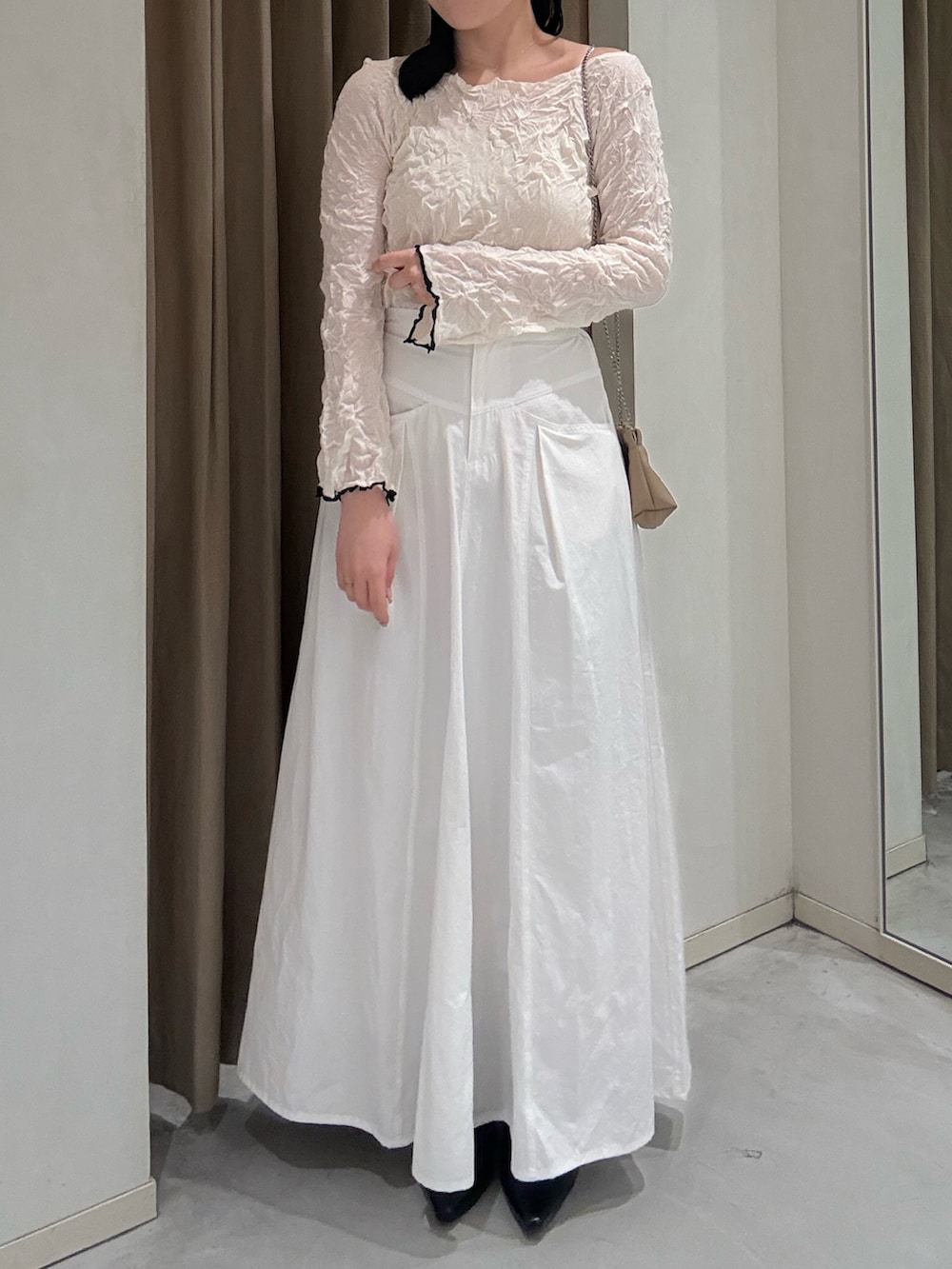 ホワイト系のニット/セーター、ブラック系のローファー、ホワイト系のスカートを着用したレディースの春コーディネートの3枚目の写真