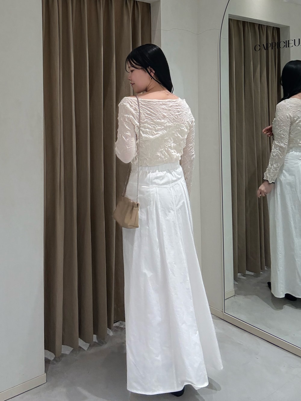 ホワイト系のニット/セーター、ブラック系のローファー、ホワイト系のスカートを着用したレディースの春コーディネートの2枚目の写真