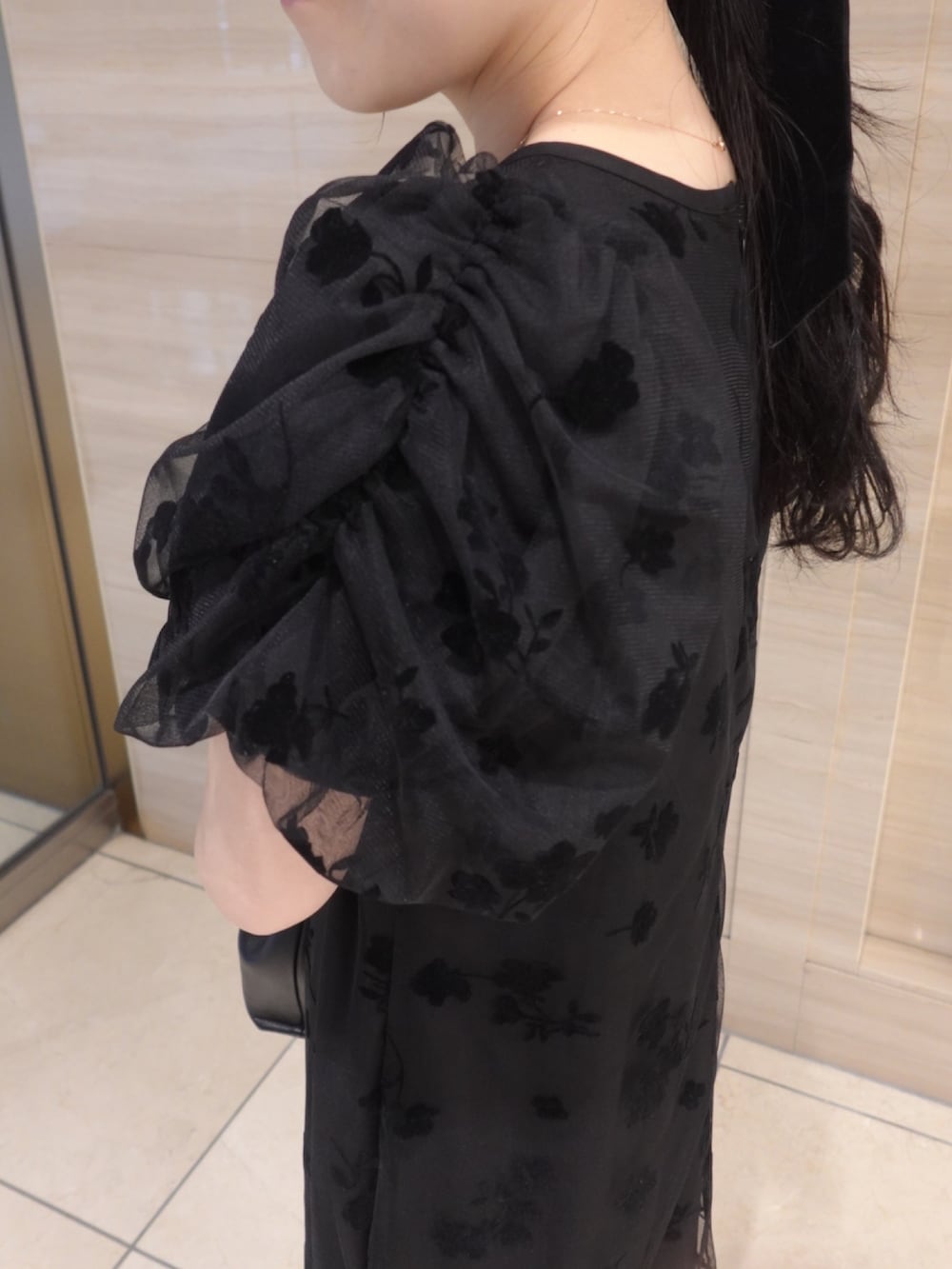 ブラック系のワンピース、ブラック系のローファー、ブラック系のショルダーバッグを着用したレディースの春コーディネートの3枚目の写真