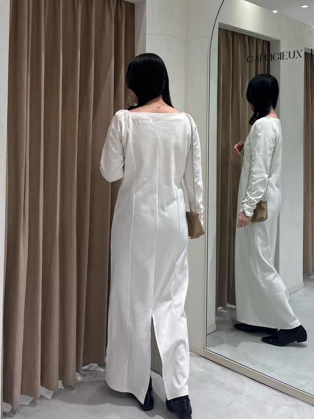 ホワイト系のワンピース、ブラック系のローファー、ベージュ系のショルダーバッグを着用したレディースの春コーディネートの3枚目の写真