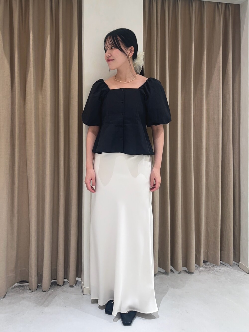 ホワイト系のスカート、ブラック系のシャツ/ブラウス、ブラック系のショルダーバッグを着用したレディースの夏コーディネートの2枚目の写真