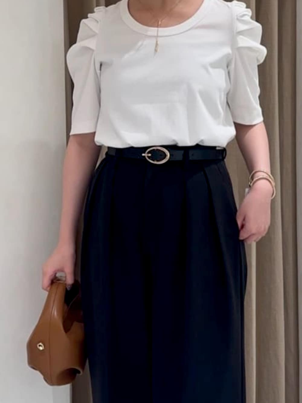 ホワイト系のTシャツ/カットソー、ブラック系のその他パンツ、ゴールド系のバングル/リストバンドを着用したレディースの夏コーディネートの2枚目の写真