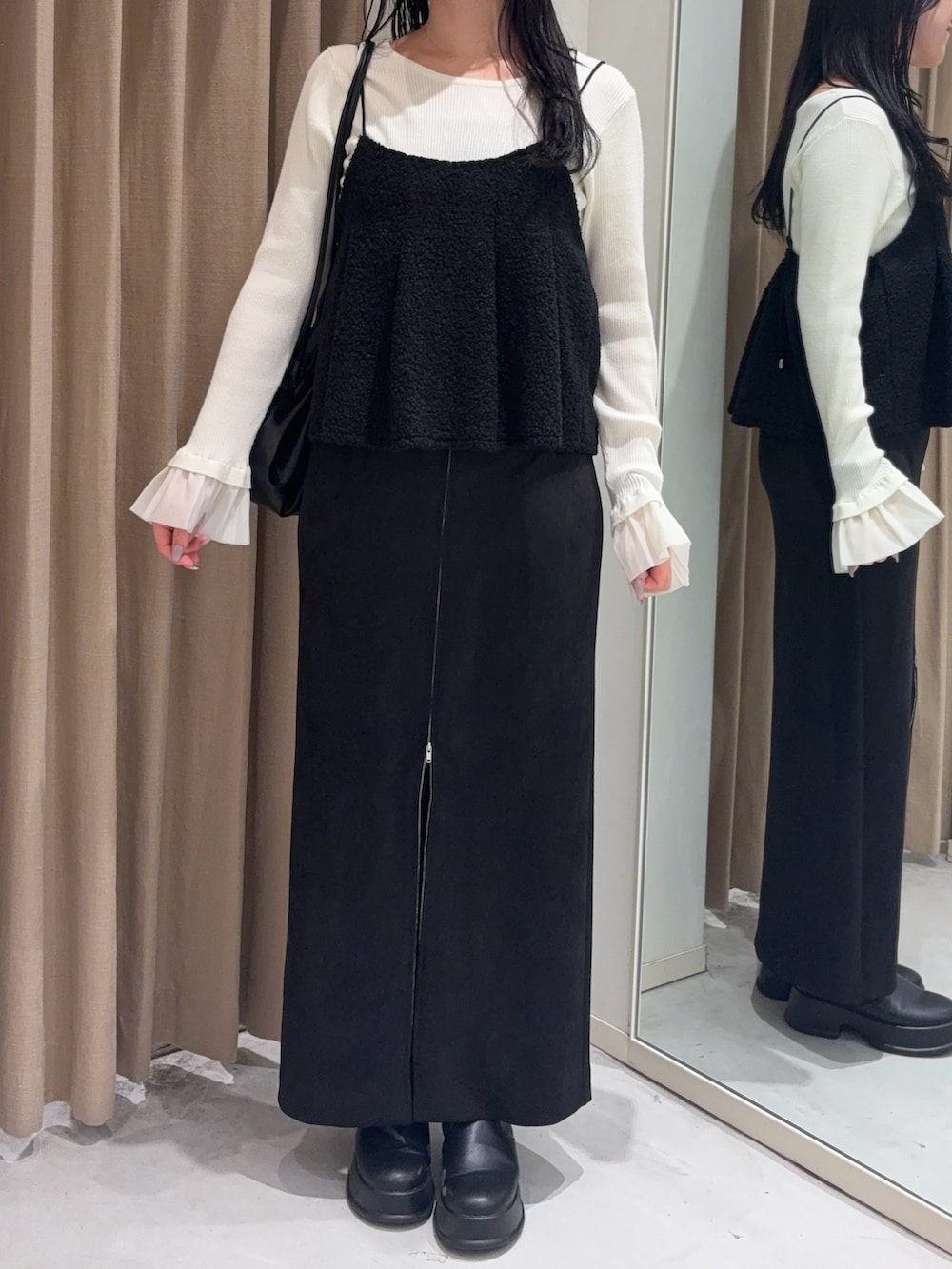 ブラック系のスカート、ブラック系のシャツ/ブラウス、ブラック系のショルダーバッグを着用したレディースの冬コーディネートの2枚目の写真