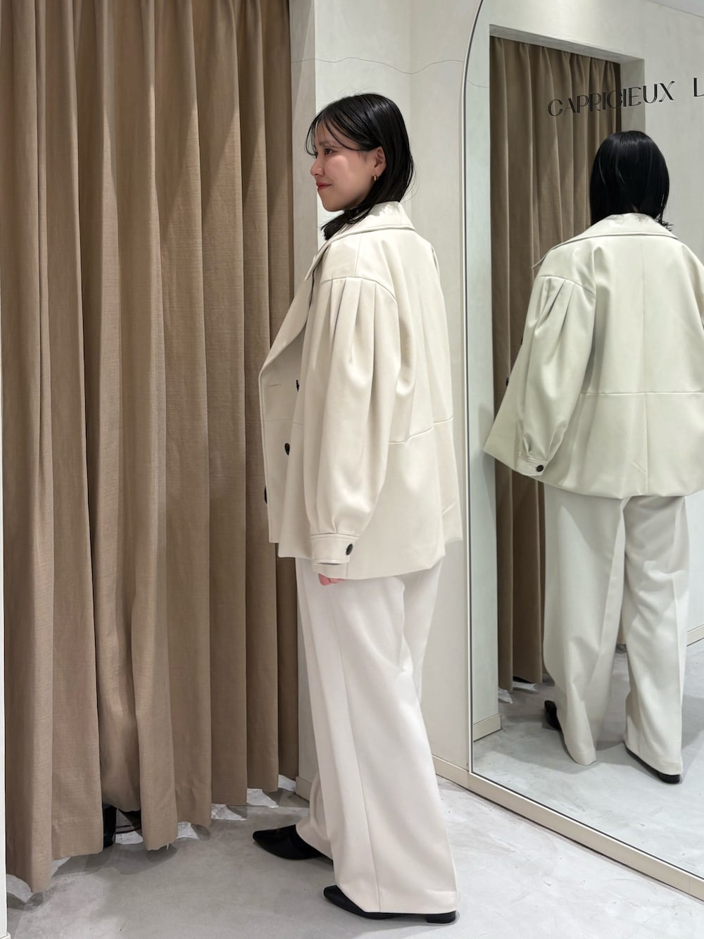 ホワイト系のその他パンツ、ホワイト系のその他アウター、ブラック系のショルダーバッグを着用したレディースの春コーディネートの2枚目の写真