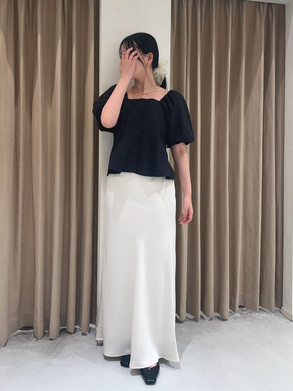 ホワイト系のスカート、ブラック系のシャツ/ブラウス、ブラック系のショルダーバッグを着用したレディースの夏コーディネートの3枚目の写真