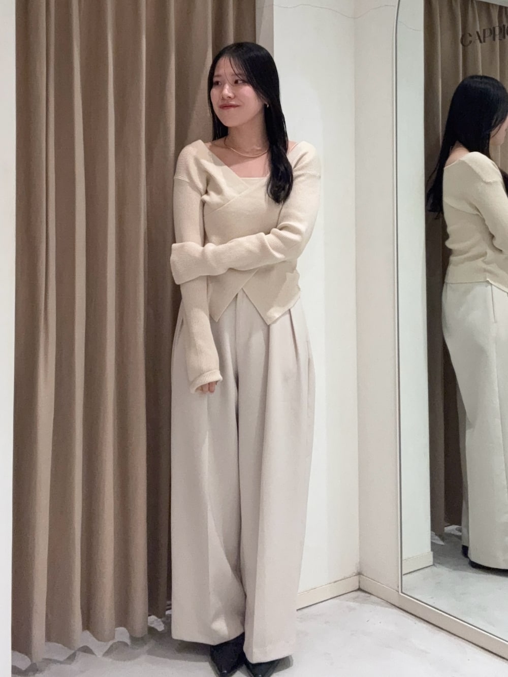 ホワイト系のその他パンツ、ベージュ系のニット/セーター、ブラック系のローファーを着用したレディースの冬コーディネートの2枚目の写真