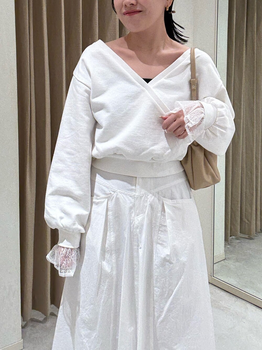 ホワイト系のスカート、ホワイト系のTシャツ/カットソー、ブラック系のパンプスを着用したレディースの春コーディネートの3枚目の写真