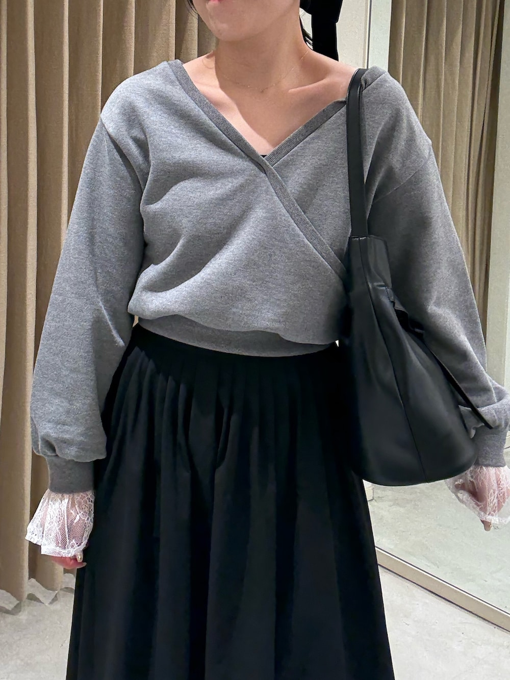 ブラック系のスカート、ブラック系のローファー、ブラック系のショルダーバッグを着用したレディースの春コーディネートの3枚目の写真