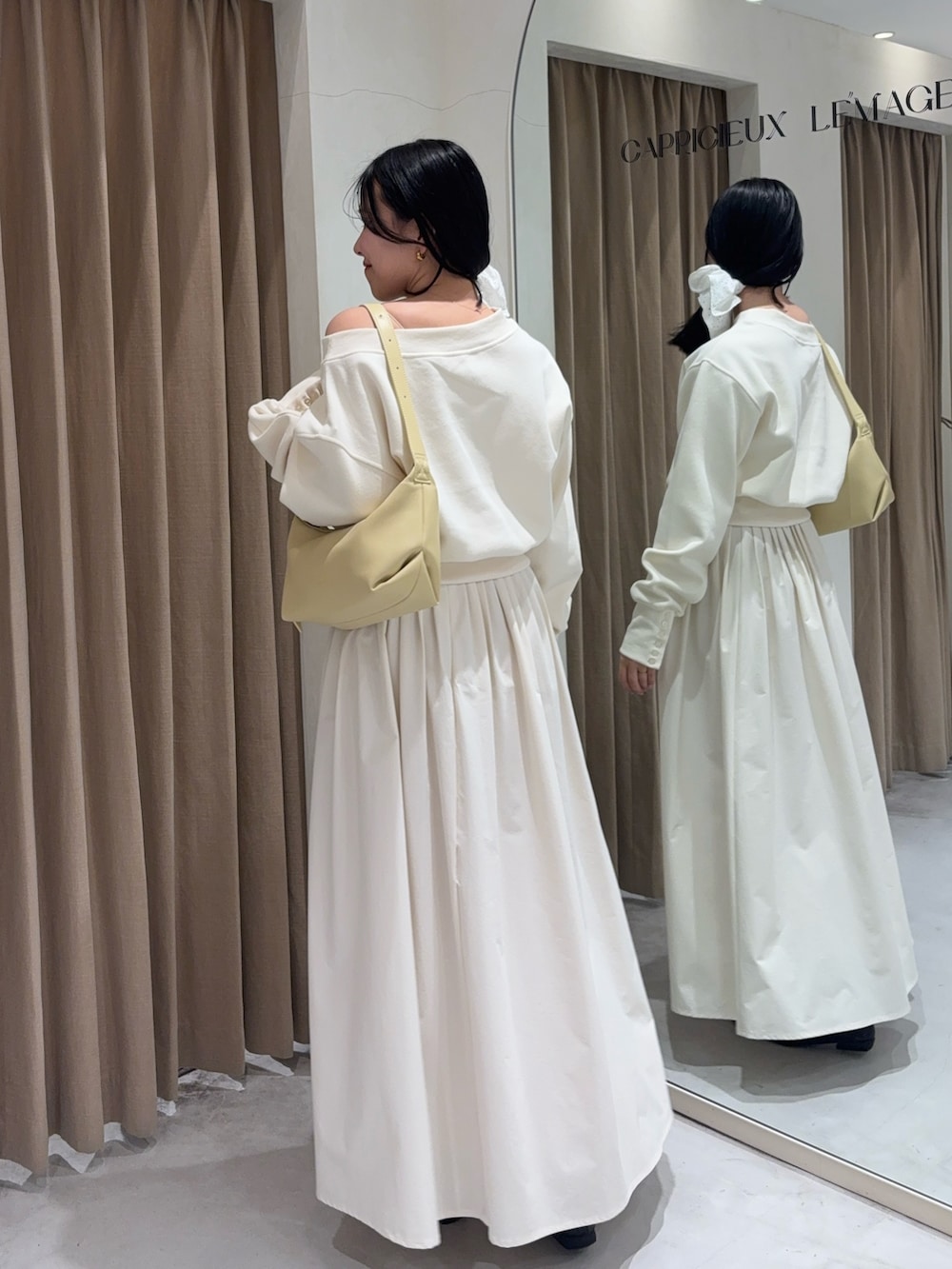 ホワイト系のスカート、ホワイト系のTシャツ/カットソー、イエロー系のショルダーバッグを着用したレディースの春コーディネートの2枚目の写真