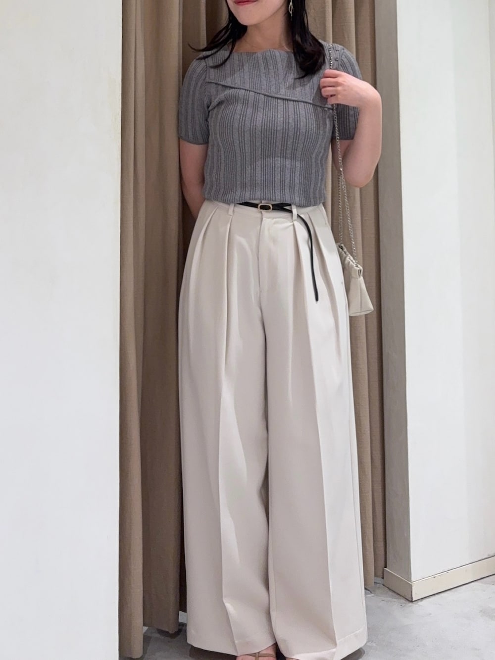 ホワイト系のその他パンツ、グレー系のニット/セーター、ホワイト系のショルダーバッグを着用したレディースの夏コーディネートの2枚目の写真