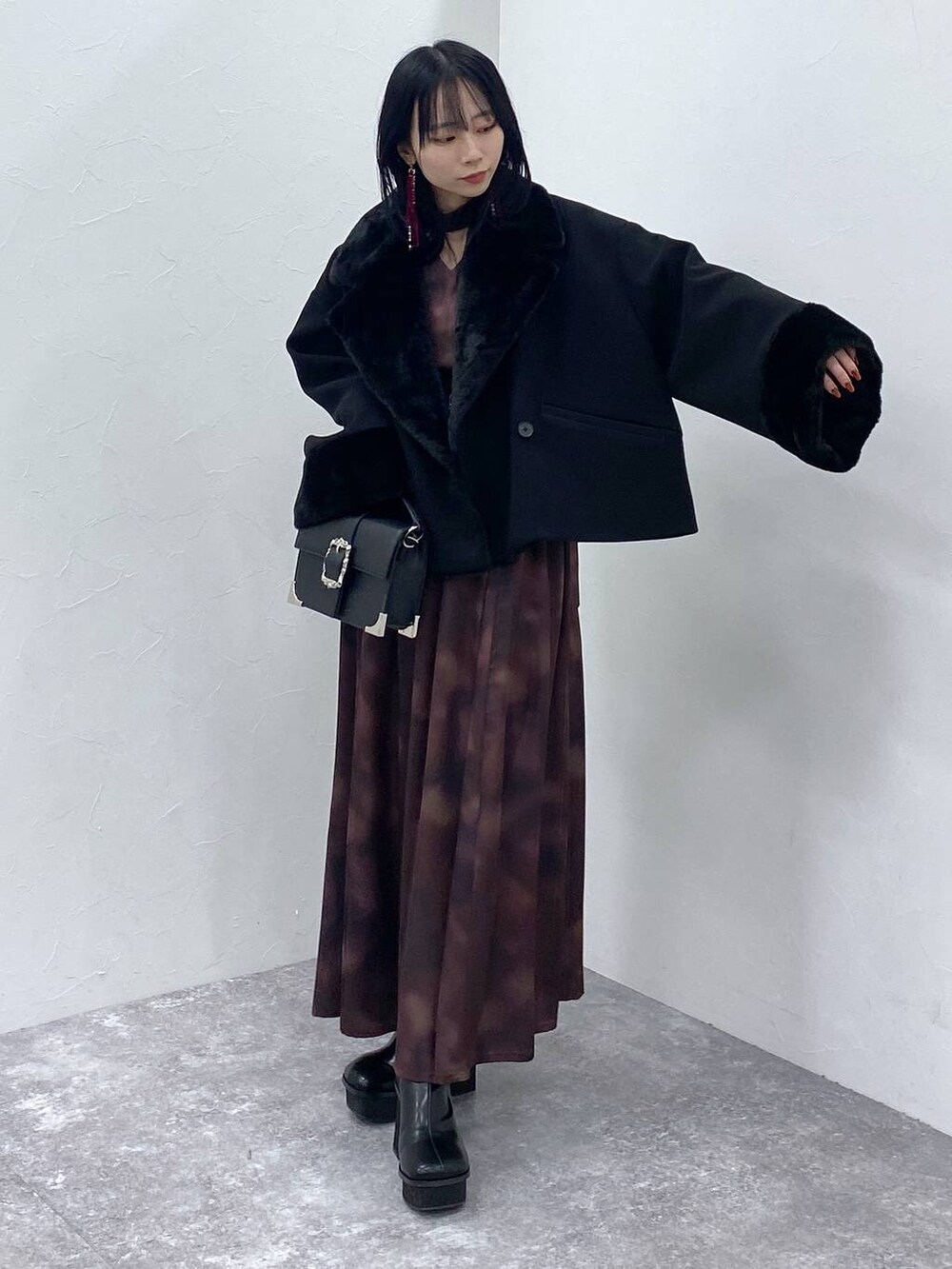 ブラック系のブーツ、ブラック系のショルダーバッグ、ブラック系のその他アウターを着用したレディースの冬コーディネートの5枚目の写真