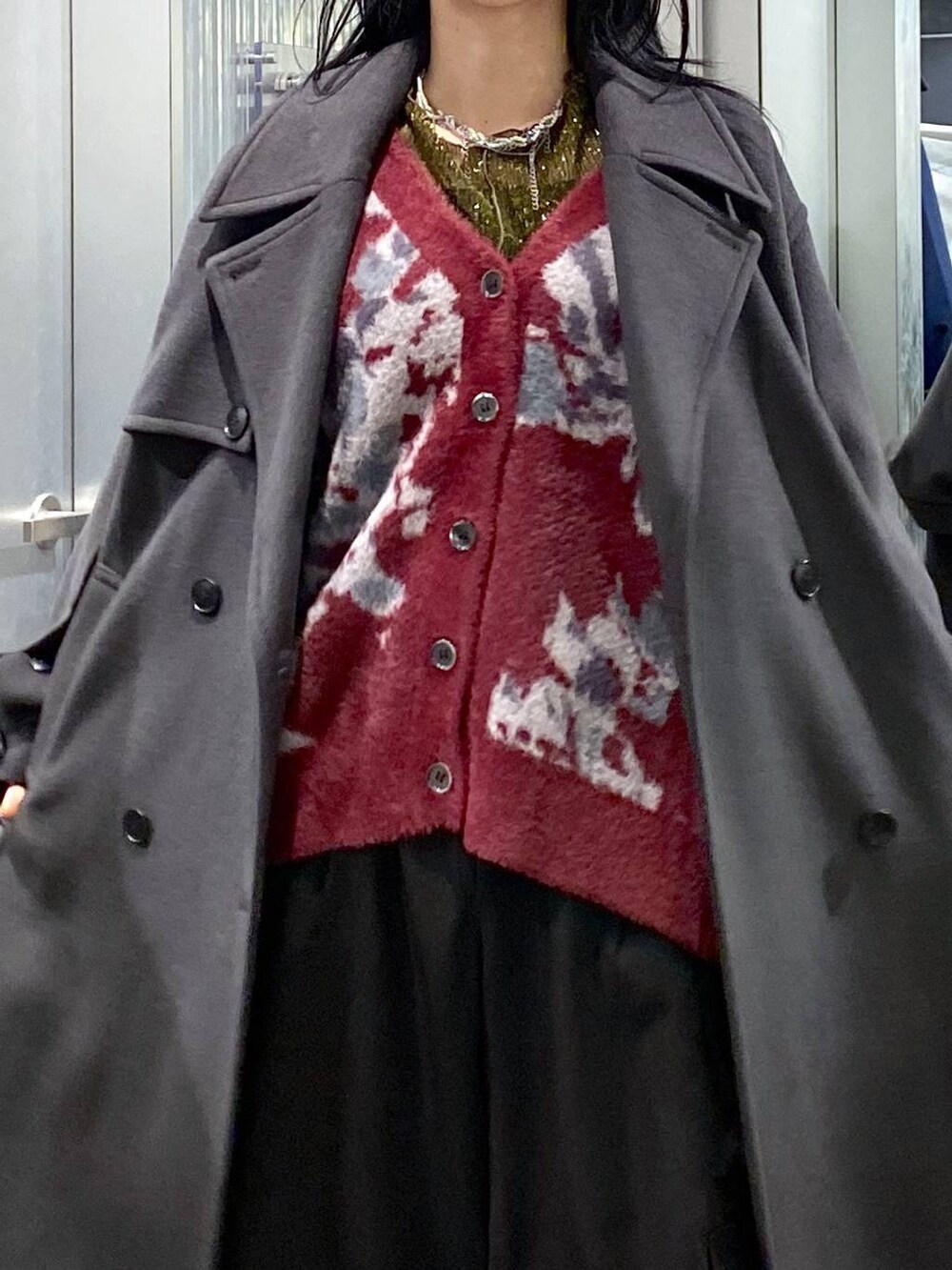 グレー系のトレンチコート、レッド系のカーディガン/ボレロ、イエロー系のTシャツ/カットソーを着用したレディースの冬コーディネートの6枚目の写真