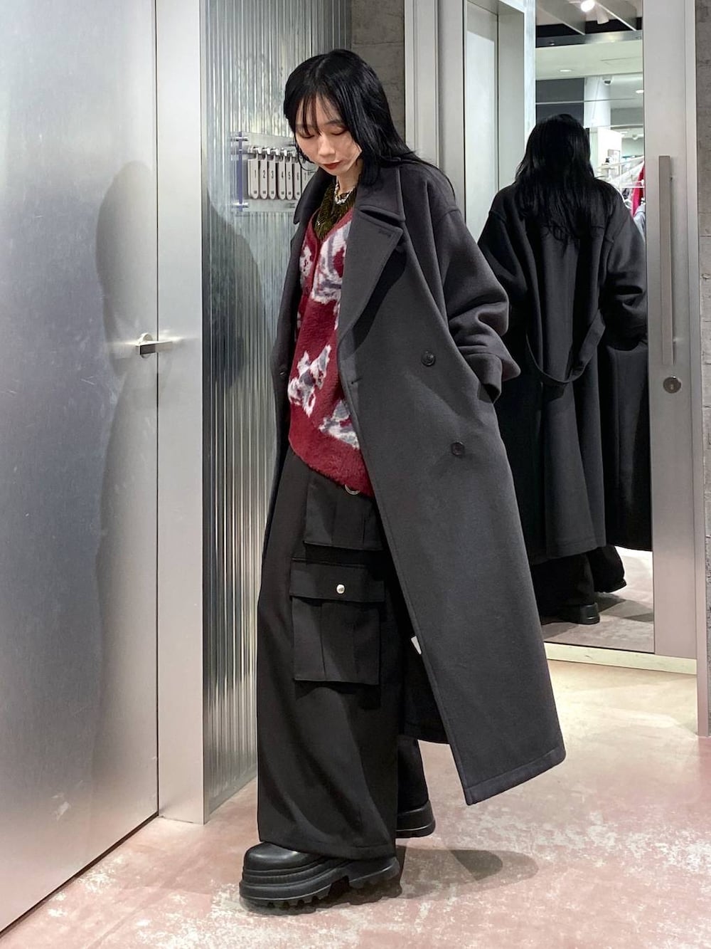 グレー系のトレンチコート、レッド系のカーディガン/ボレロ、イエロー系のTシャツ/カットソーを着用したレディースの冬コーディネートの5枚目の写真