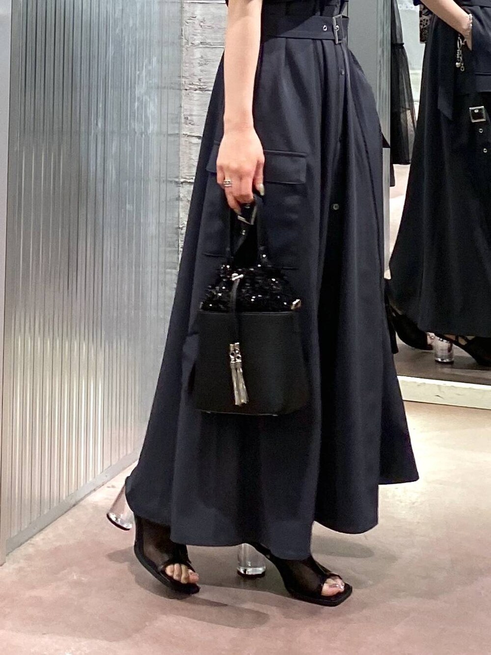 ブラック系のサンダル、グレー系のワンピース、ブラック系のショルダーバッグを着用したレディースの夏コーディネートの8枚目の写真