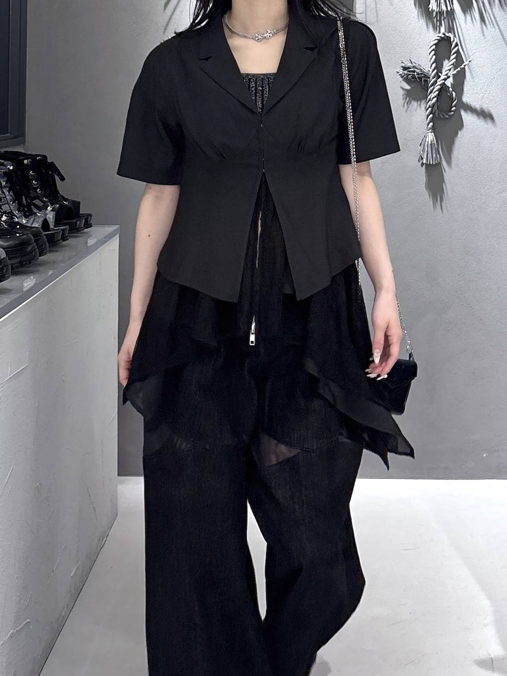 ブラック系のタンクトップ、ブラック系のサンダル、ブラック系のデニムパンツを着用したレディースの春コーディネートの7枚目の写真