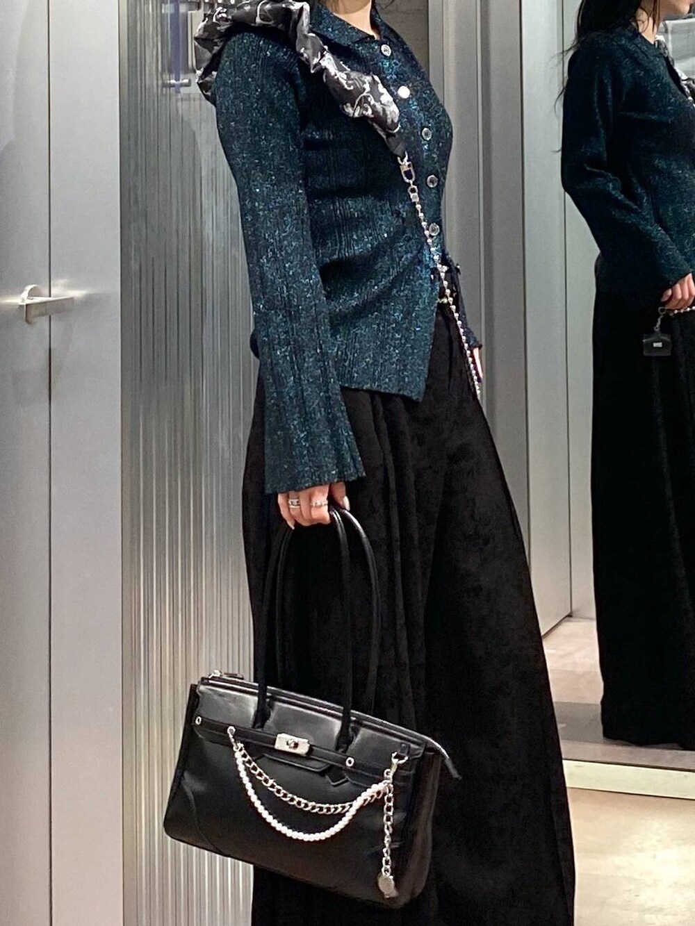 ブラック系のブーツ、ブラック系のボストンバッグ、グリーン系のカーディガン/ボレロを着用したレディースの冬コーディネートの9枚目の写真