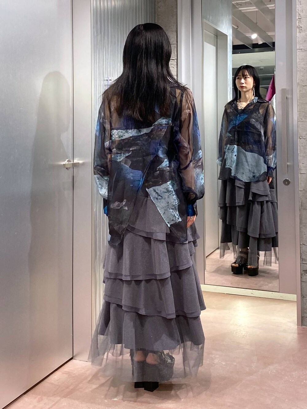 ブラック系のサンダル、ブラック系のタンクトップ、グレー系のスカートを着用したレディースの夏コーディネートの3枚目の写真