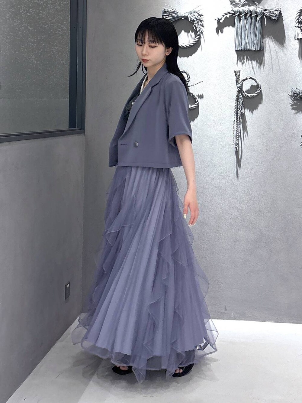 ブラック系のタンクトップ、パープル系のスカート、ブラック系のサンダルを着用したレディースの春コーディネートの9枚目の写真