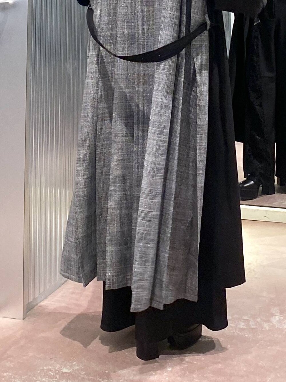 ブラック系のブーツ、ブラック系のステンカラーコート、ブラック系のTシャツ/カットソーを着用したレディースの秋コーディネートの8枚目の写真