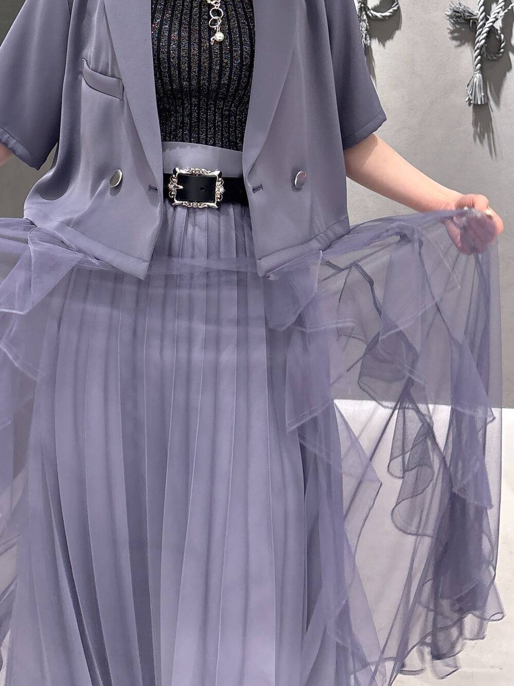 ブラック系のタンクトップ、パープル系のスカート、ブラック系のサンダルを着用したレディースの春コーディネートの8枚目の写真