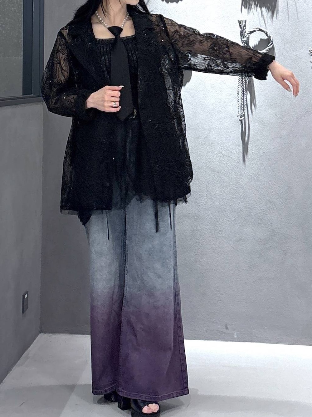 ブラック系のネクタイ、ブラック系のタンクトップ、ブラック系のテーラードジャケットを着用したレディースの春コーディネートの8枚目の写真