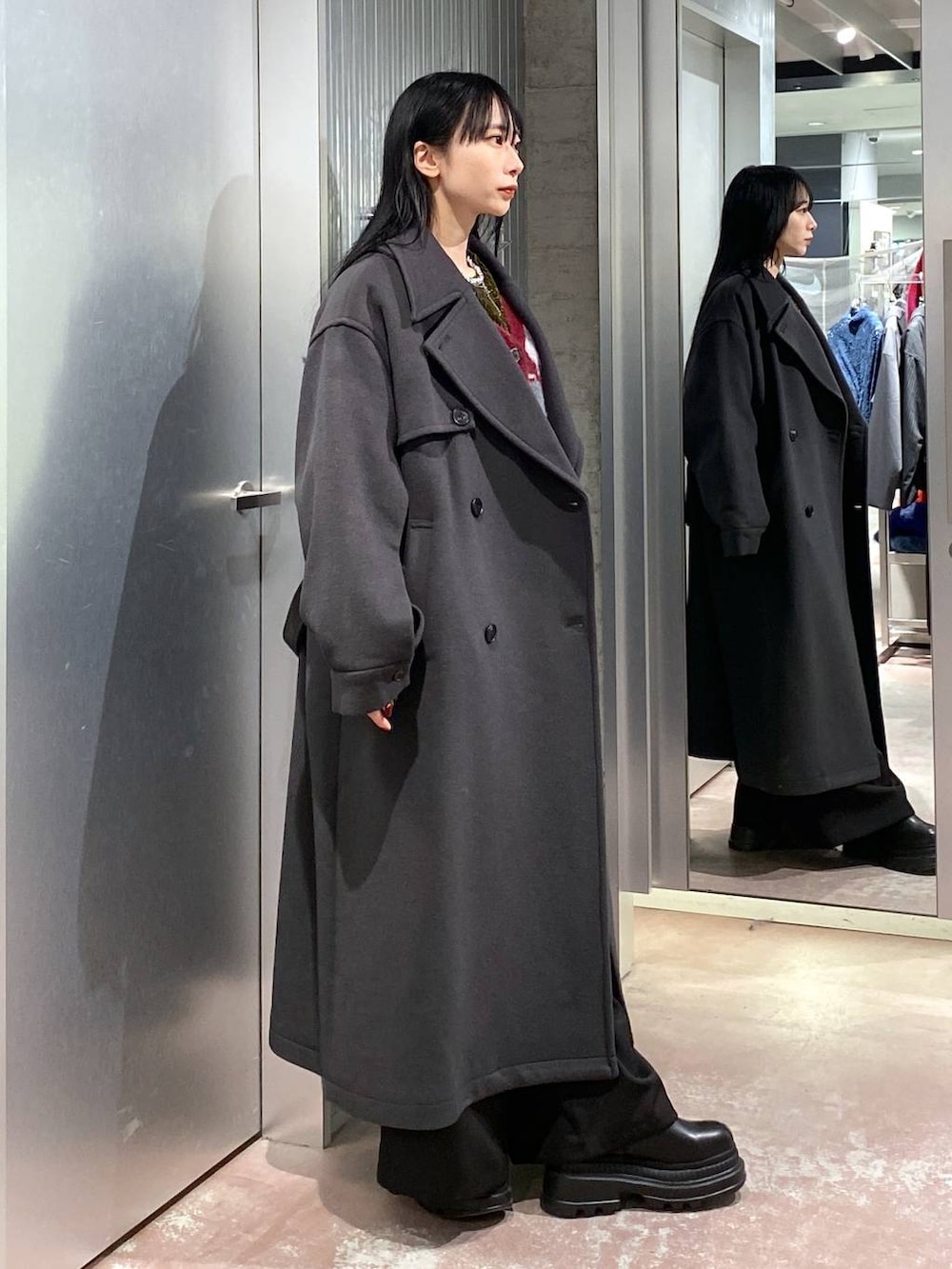 グレー系のトレンチコート、レッド系のカーディガン/ボレロ、イエロー系のTシャツ/カットソーを着用したレディースの冬コーディネートの4枚目の写真