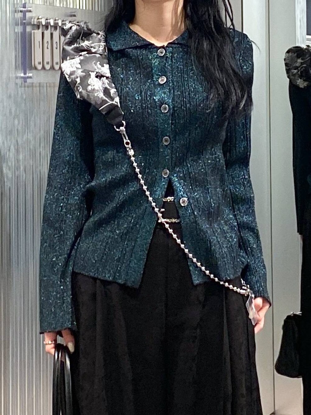 ブラック系のブーツ、ブラック系のボストンバッグ、グリーン系のカーディガン/ボレロを着用したレディースの冬コーディネートの6枚目の写真