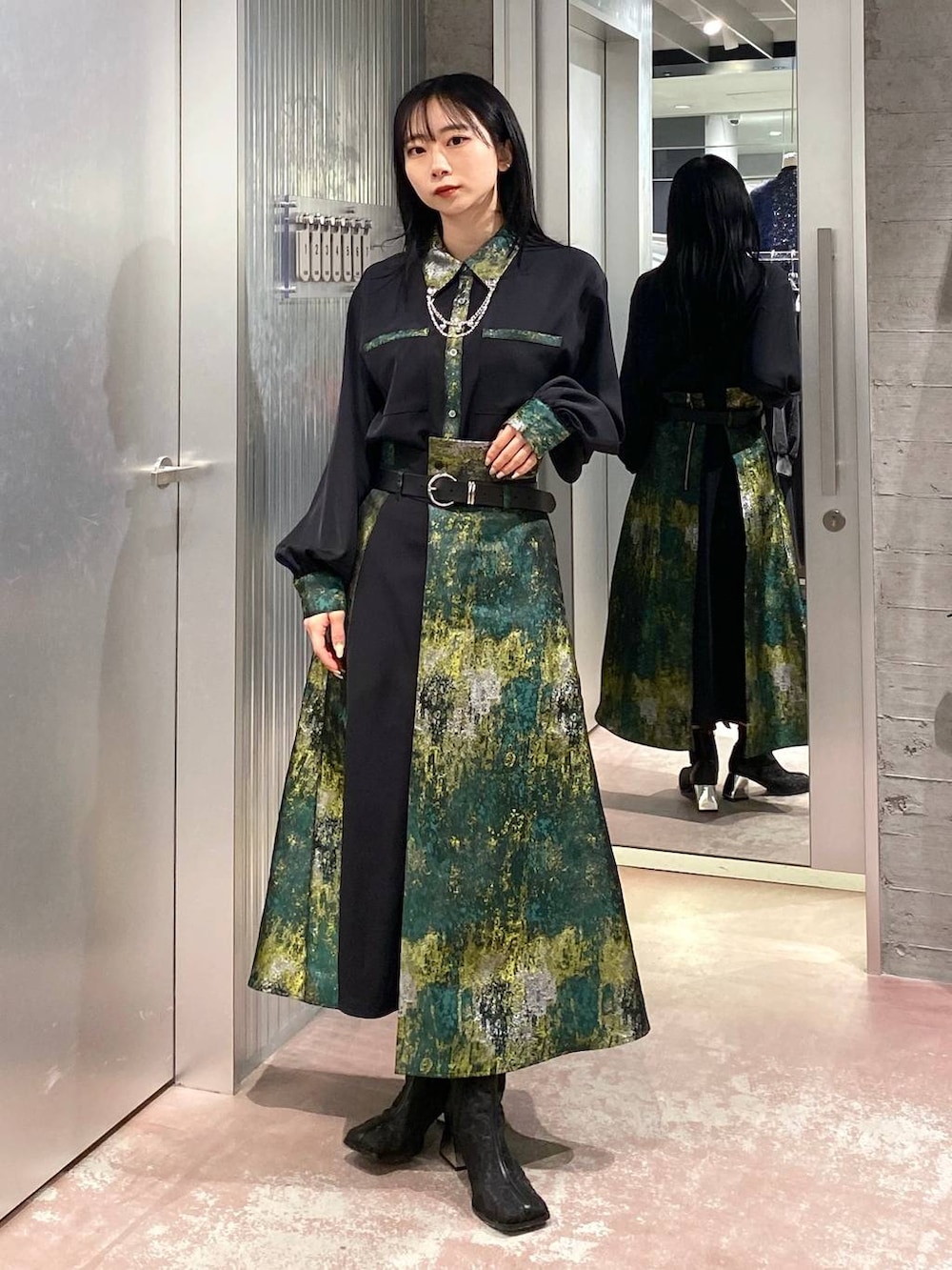 ブラック系のブーツ、イエロー系のスカート、ブラック系のショルダーバッグを着用したレディースの冬コーディネートの7枚目の写真