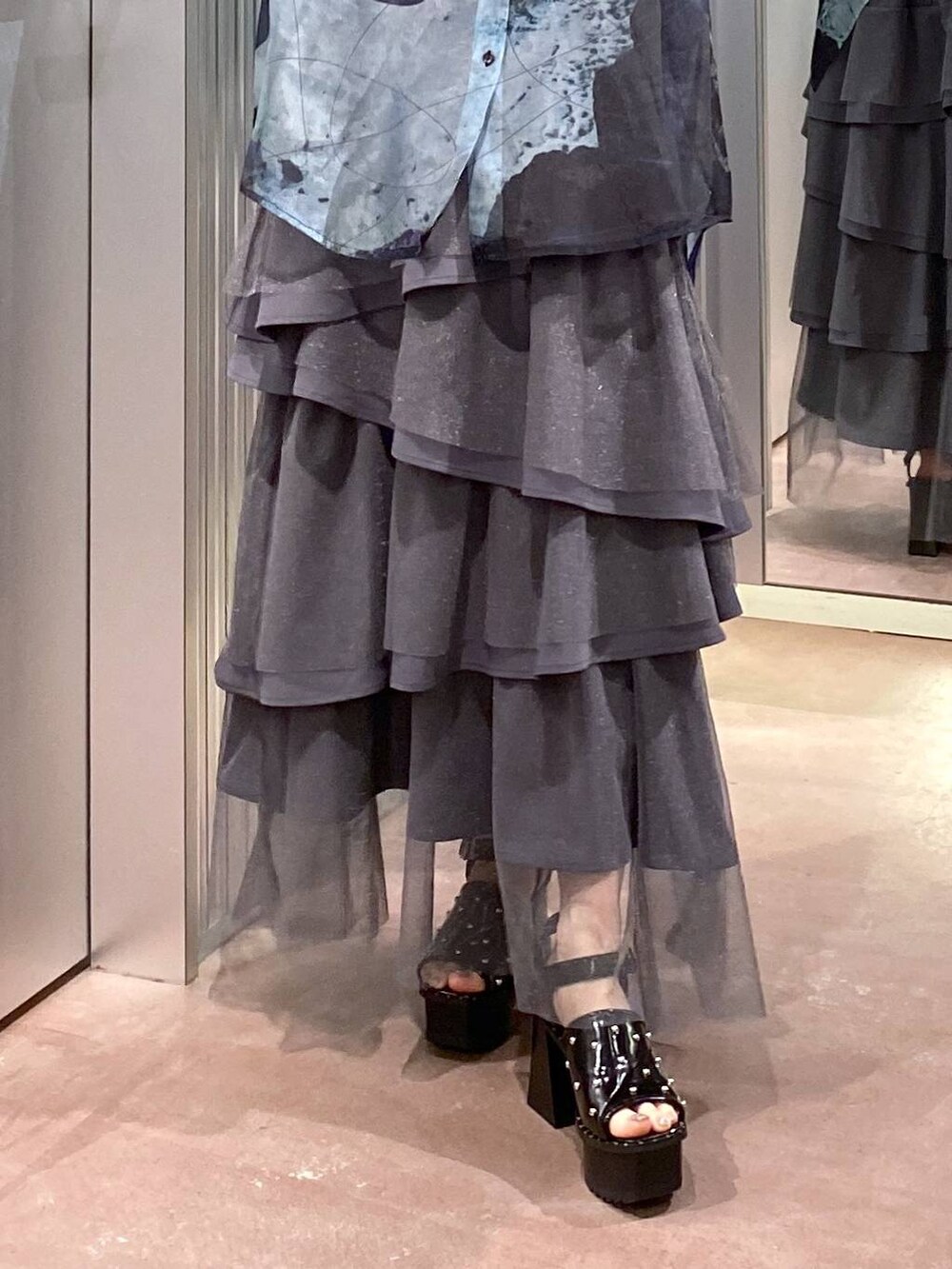 ブラック系のサンダル、ブラック系のタンクトップ、グレー系のスカートを着用したレディースの夏コーディネートの9枚目の写真