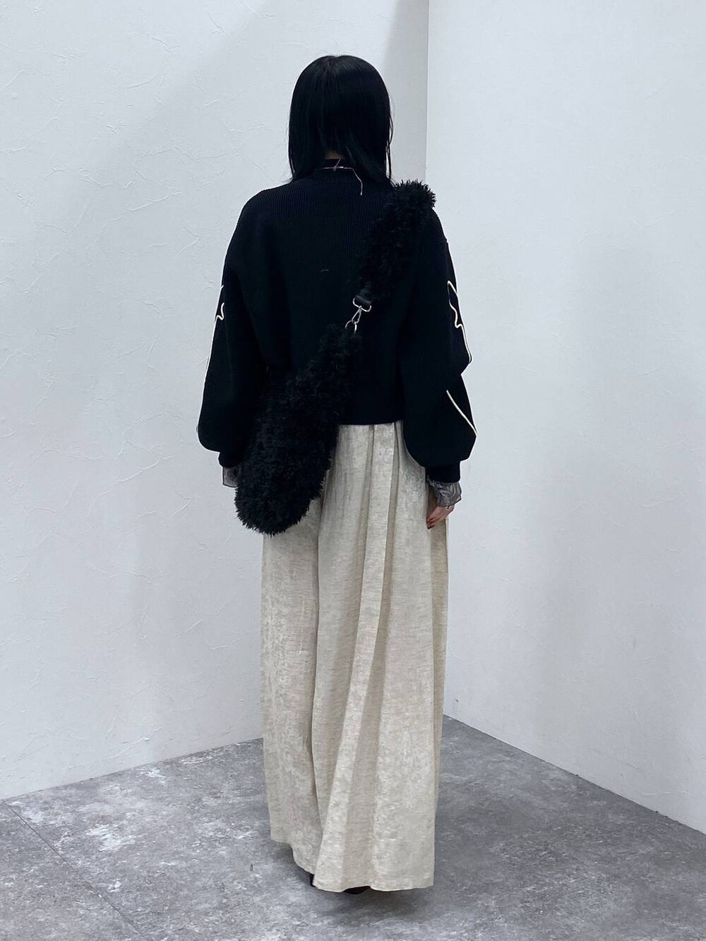 ブラック系のブーツ、ブラック系のショルダーバッグ、ブラック系のニット/セーターを着用したレディースの冬コーディネートの3枚目の写真