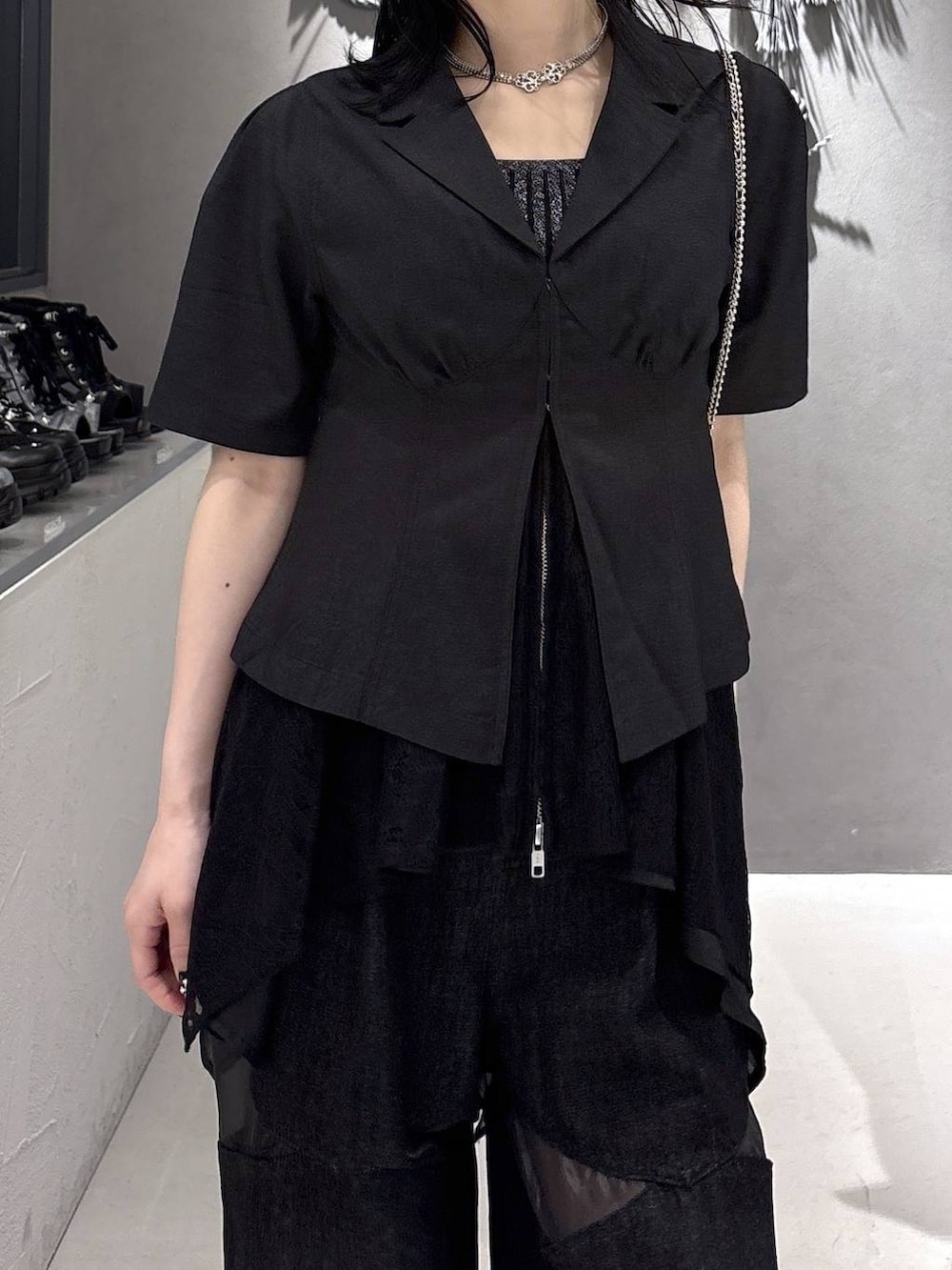 ブラック系のタンクトップ、ブラック系のサンダル、ブラック系のデニムパンツを着用したレディースの春コーディネートの6枚目の写真