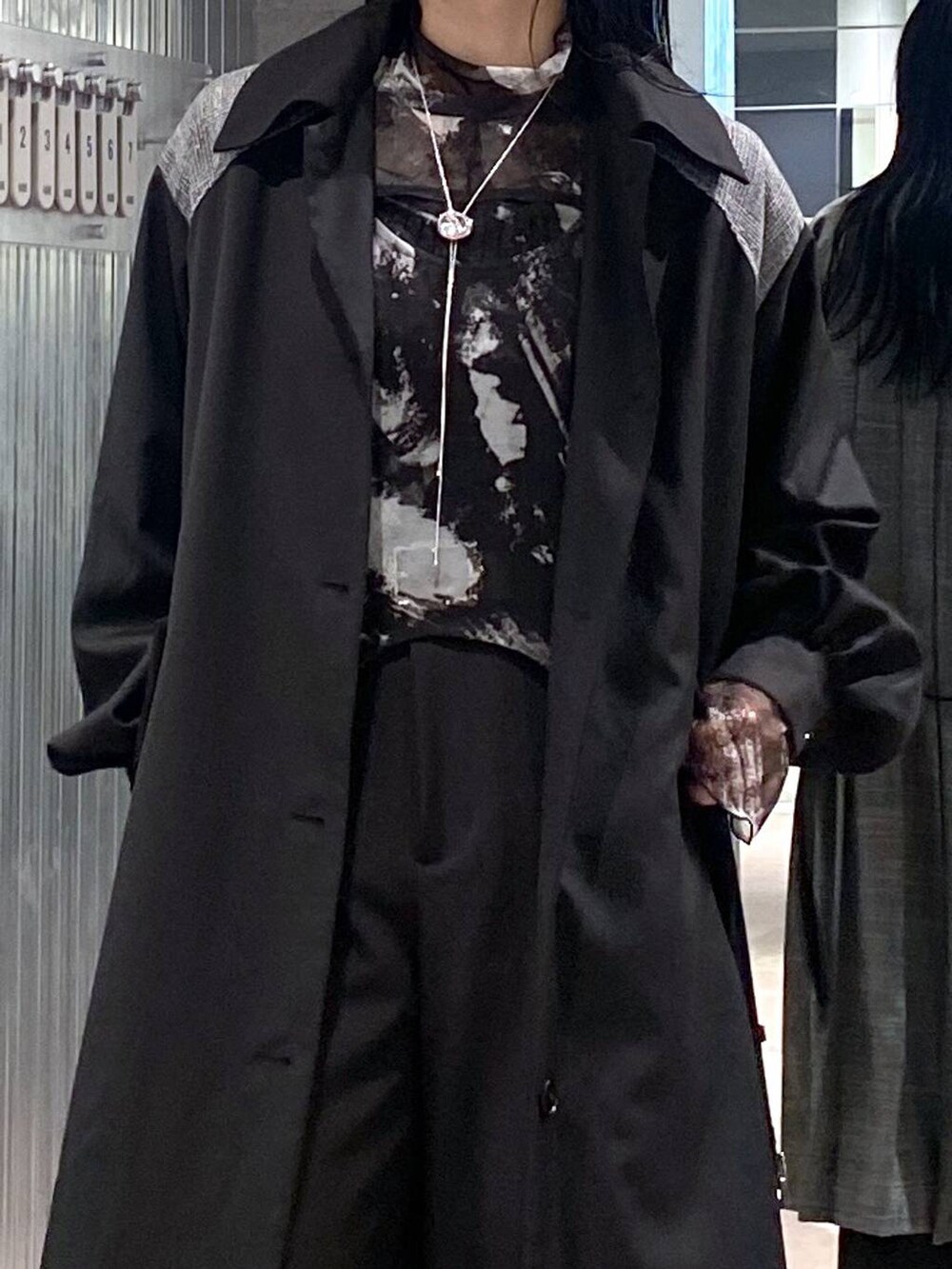 ブラック系のブーツ、ブラック系のステンカラーコート、ブラック系のTシャツ/カットソーを着用したレディースの秋コーディネートの5枚目の写真