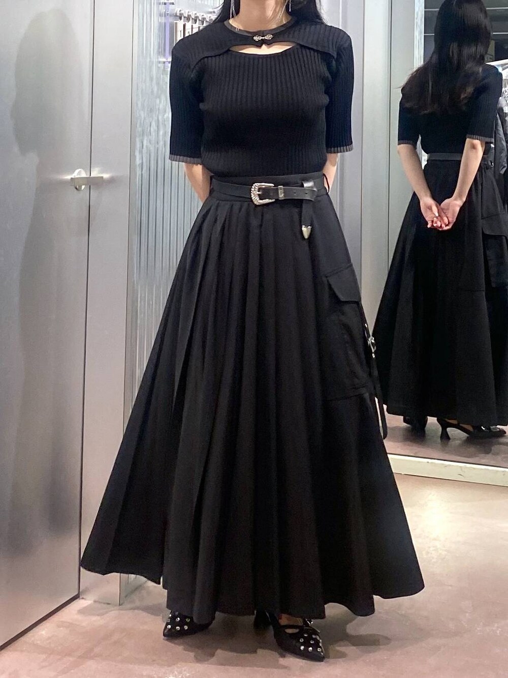 ブラック系のニット/セーター、ブラック系のパンプス、ブラック系のスカートを着用したレディースの夏コーディネートの7枚目の写真