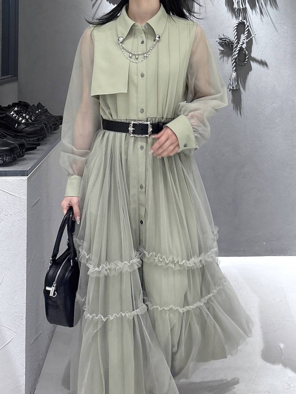 ブラック系のパンプス、ブラック系のショルダーバッグ、イエロー系のワンピースを着用したレディースの春コーディネートの5枚目の写真