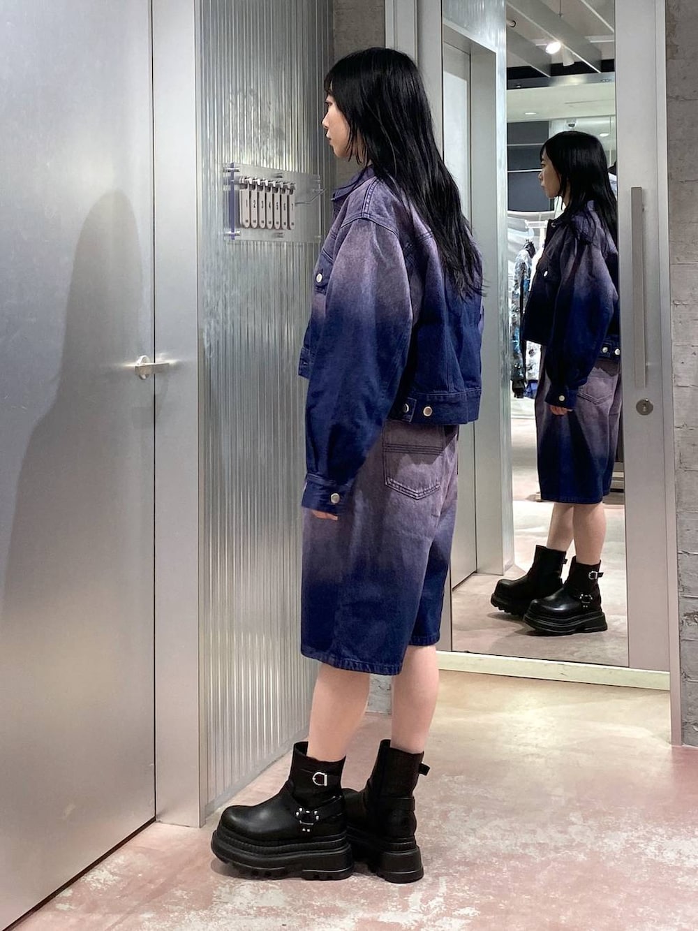 グレー系のニット/セーター、ブラック系のブーツ、パープル系のデニムジャケットを着用したレディースの冬コーディネートの3枚目の写真