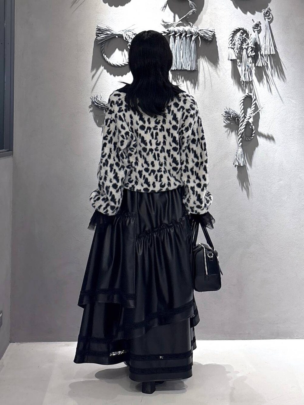 ブラック系のTシャツ/カットソー、ブラック系のボストンバッグ、ブラウン系のブーツを着用したレディースの秋コーディネートの3枚目の写真