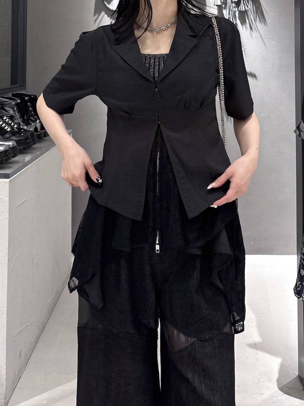 ブラック系のタンクトップ、ブラック系のサンダル、ブラック系のデニムパンツを着用したレディースの春コーディネートの8枚目の写真